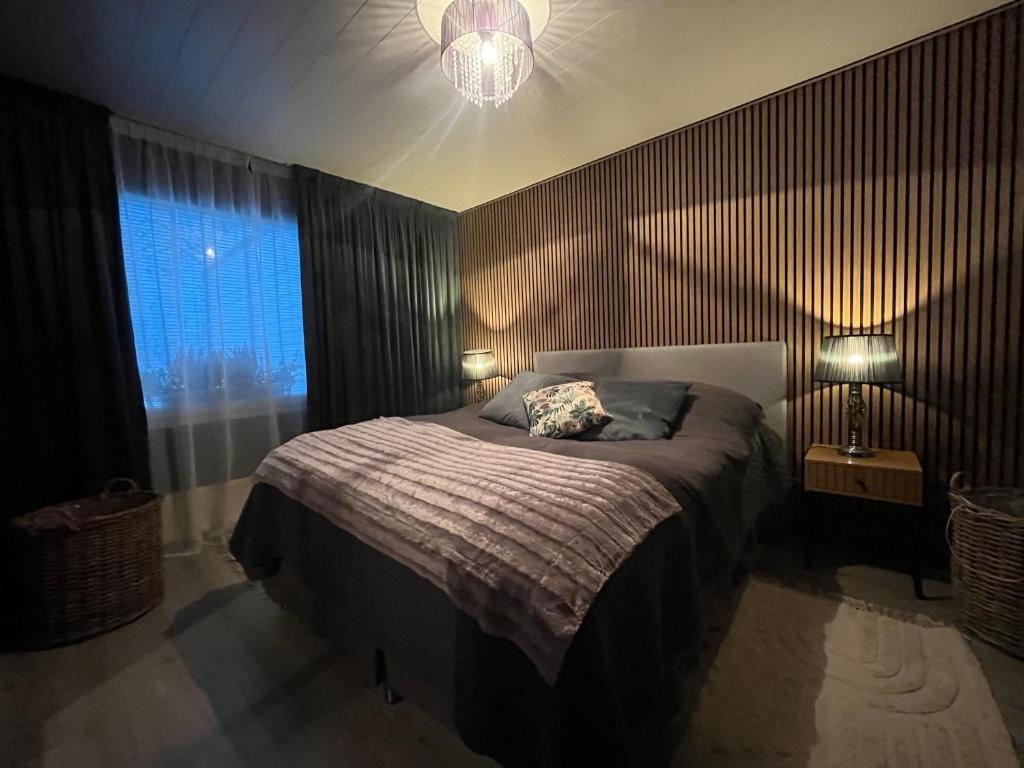 una camera da letto con un letto, una lampada e una finestra di Apartment Northernlightroad a Rovaniemi