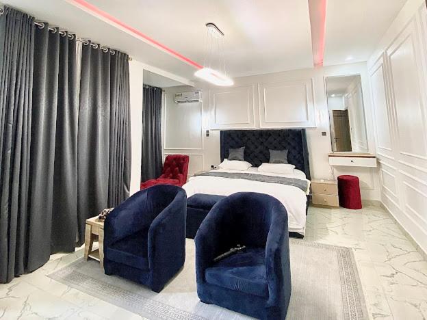 a bedroom with two blue chairs and a bed at House 8 in Lekki