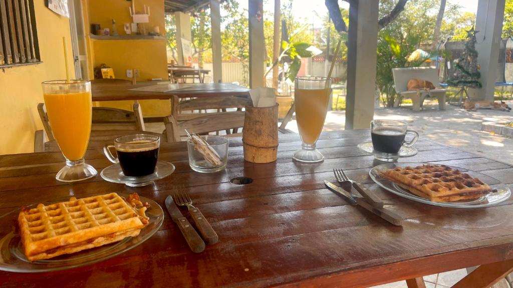 a wooden table with waffles and two glasses of beer at El Gringo in Cabo de Santo Agostinho