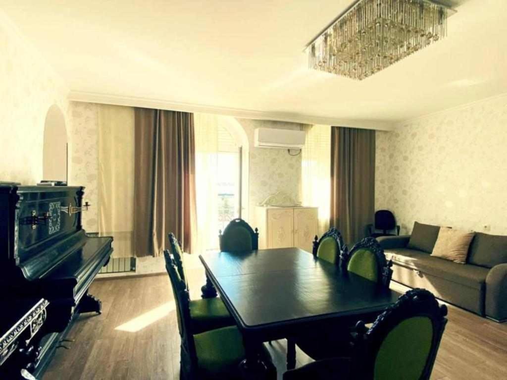 uma sala de estar com uma mesa e um sofá em Bright & Spacious Family House em Tbilisi