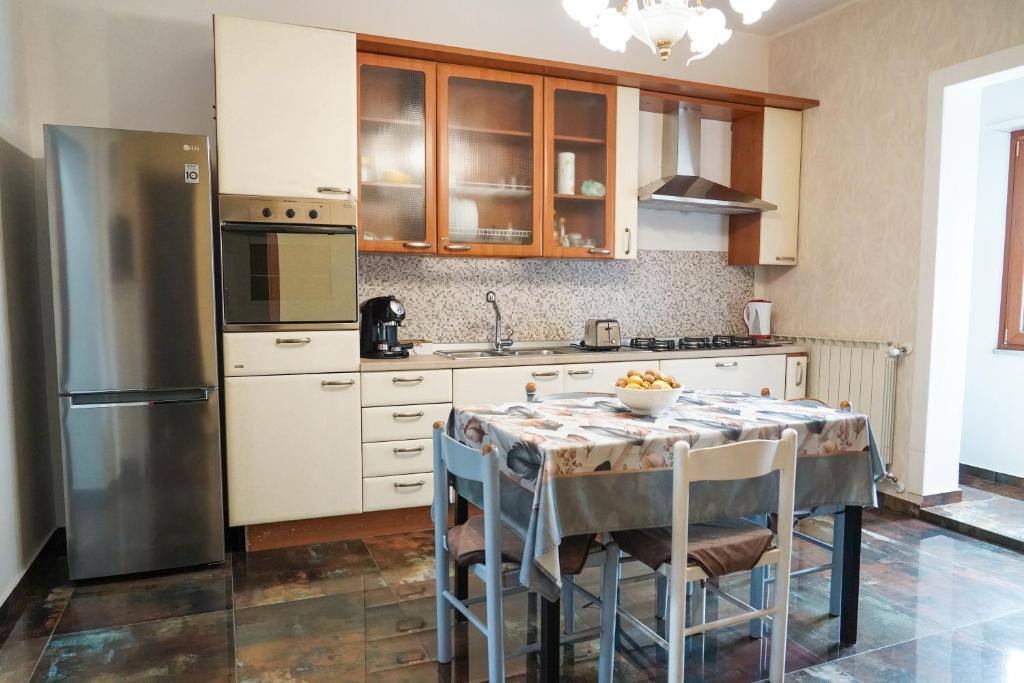 a kitchen with a table with chairs and a refrigerator at Calabria is Home in Crotone