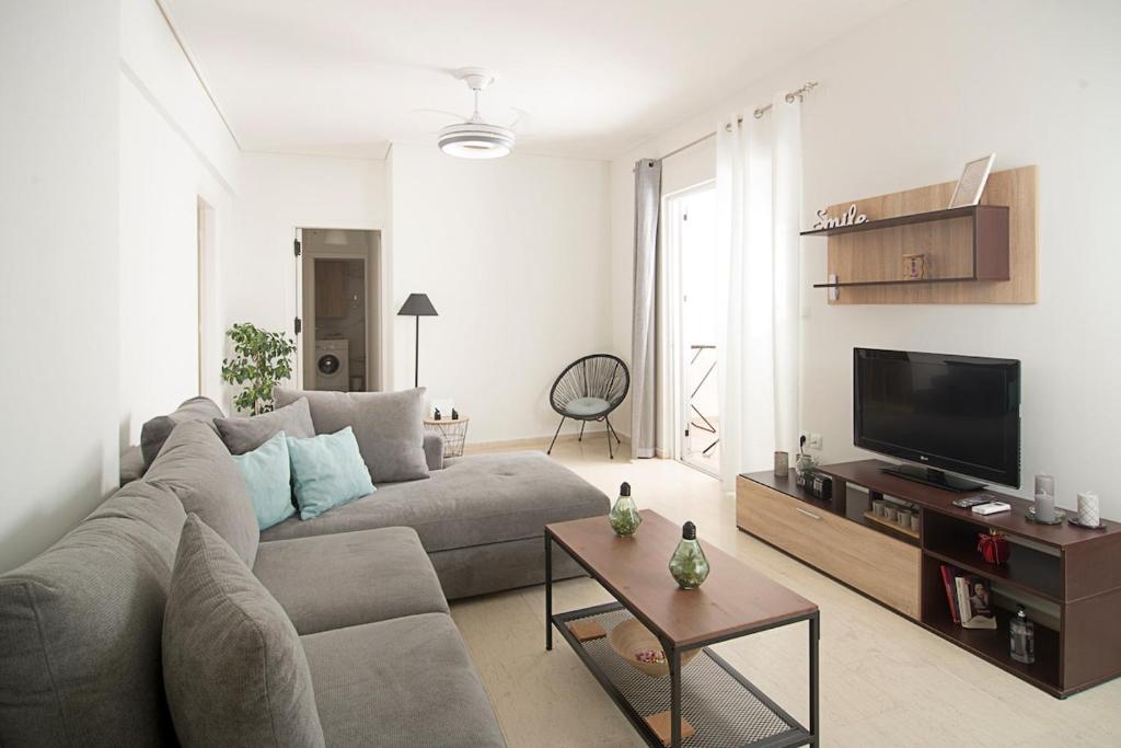 ein Wohnzimmer mit Sofa und Flachbildfernseher in der Unterkunft Ioulia in Kalamata
