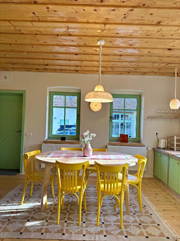 a dining room with a yellow table and chairs at Porumbacu 216 in Porumbacu de Sus