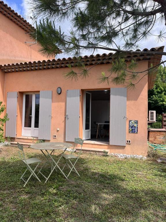 a house with a table and chairs in the yard at Charmante petite maison provençale in Grasse