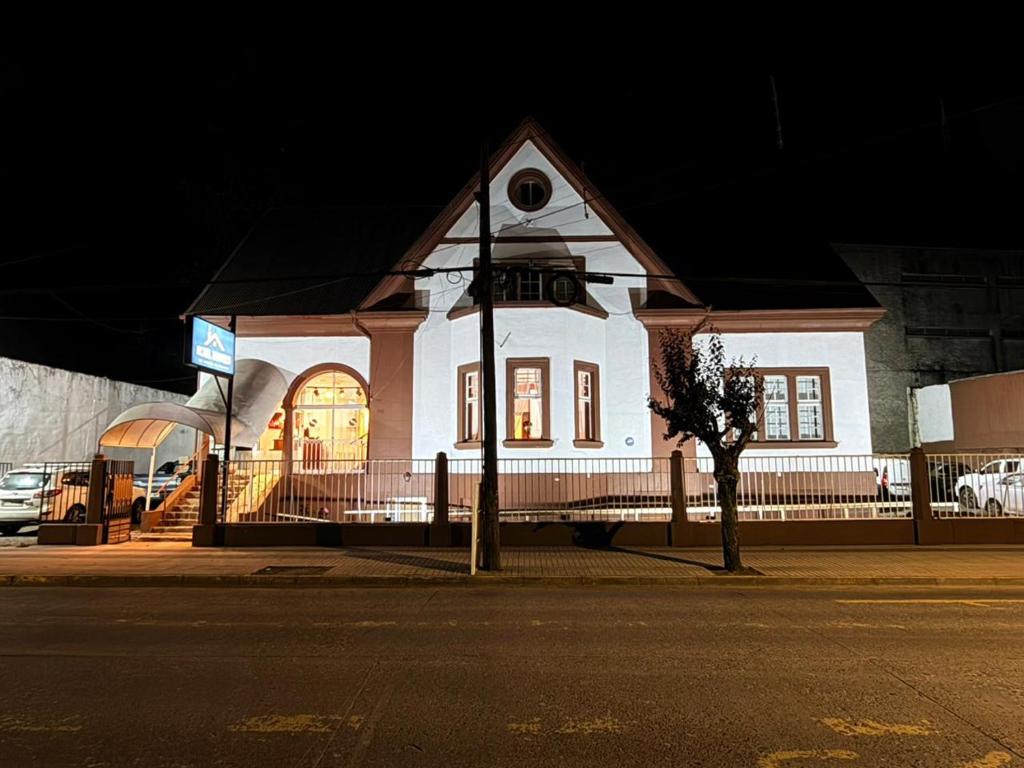 a white building on a city street at night at Travels Hotel in Osorno