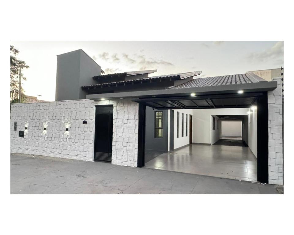 un edificio in mattoni bianchi con un garage aperto di Casa ampla próxima ao centro a Dourados