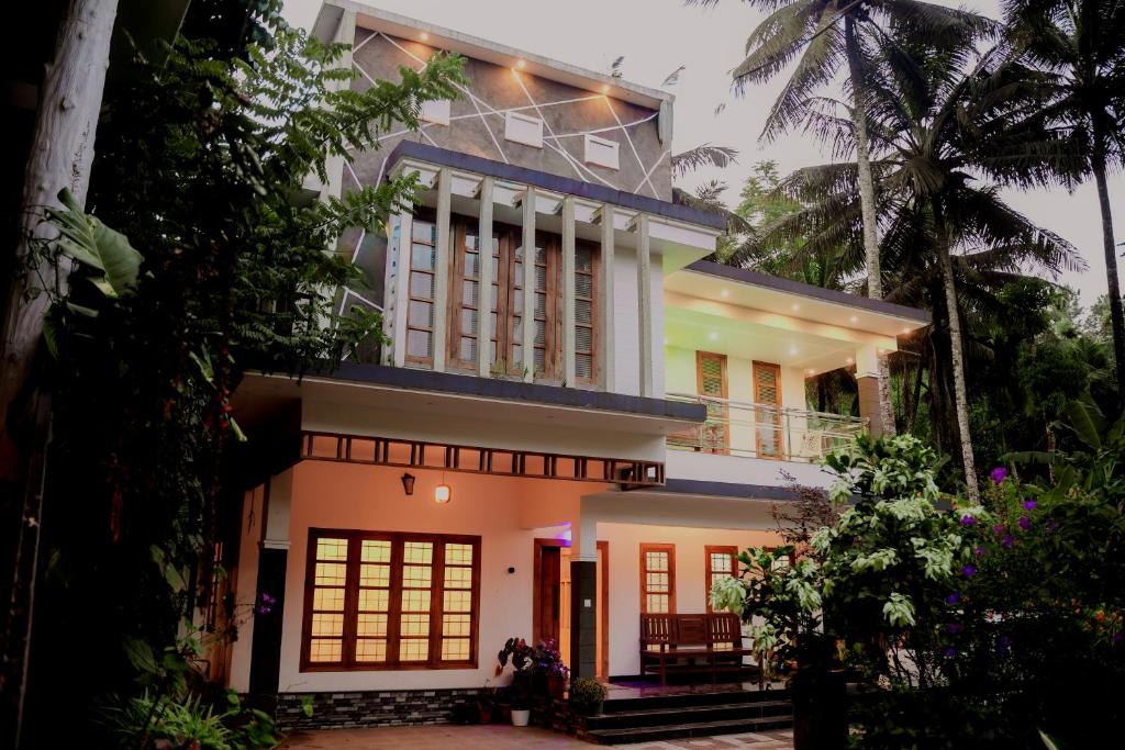 a large white house with a balcony at Dean Dale Cottages in Thekkady