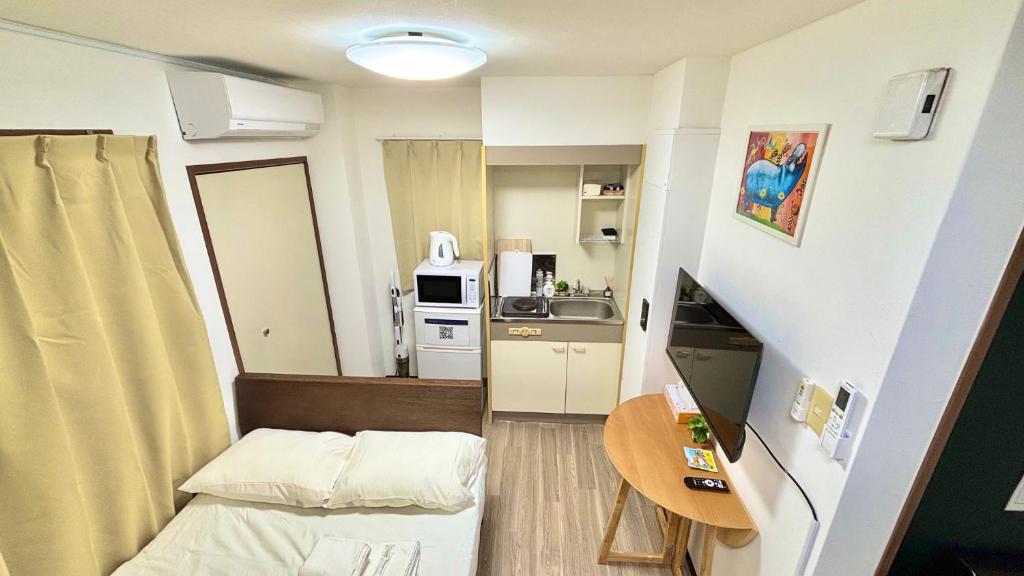 a small room with a bed and a kitchen at Good One Awaji Accessia 401 in Osaka