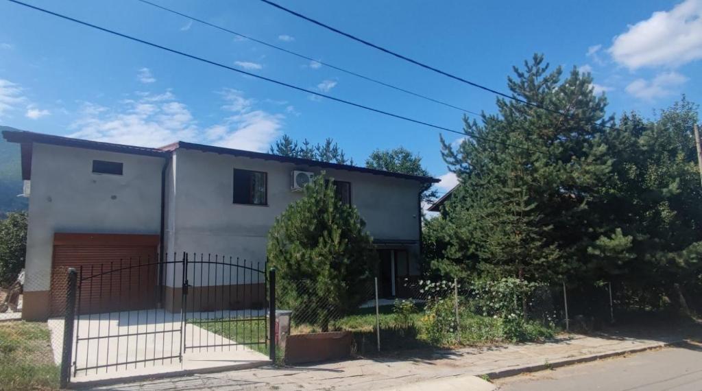 una casa bianca con cancello e alberi di Jenny House a Sapareva Banya