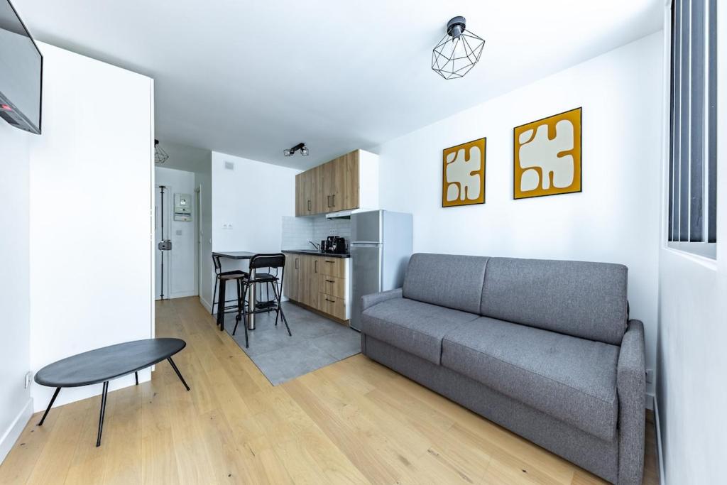 a living room with a couch and a kitchen at Comfortable Apartment , Porte-Dorée District, Paris in Paris