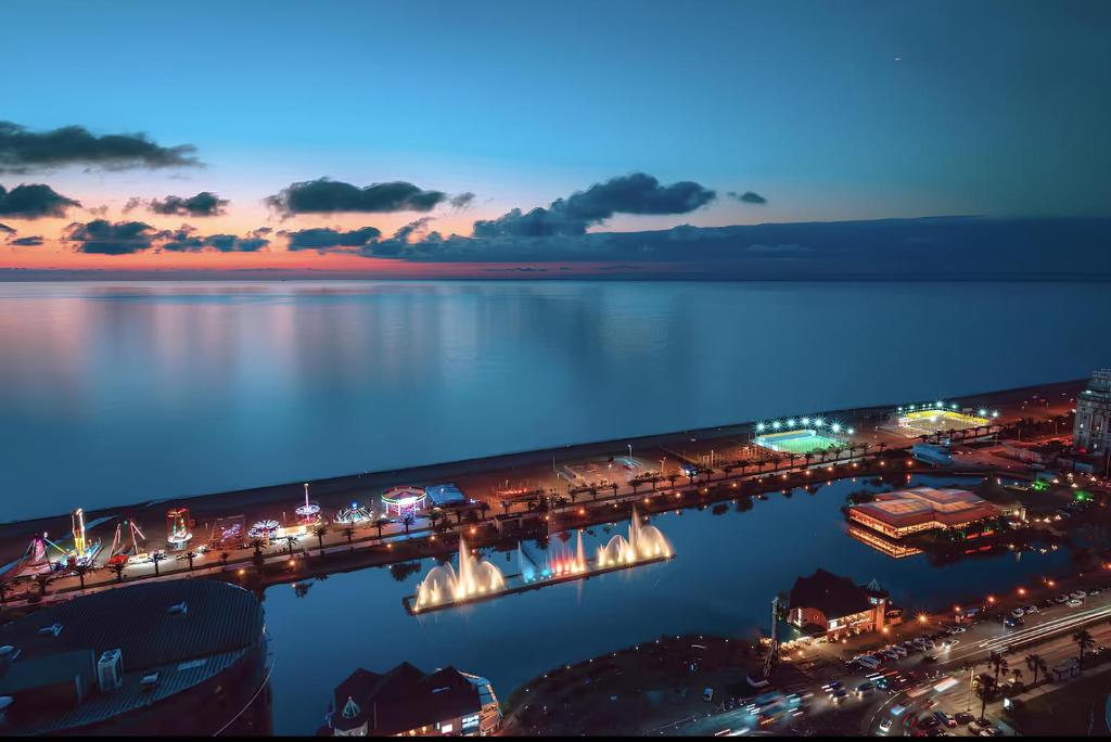 巴统SeaView Suite with panoramic view的一座夜间与城市在水面上的桥梁