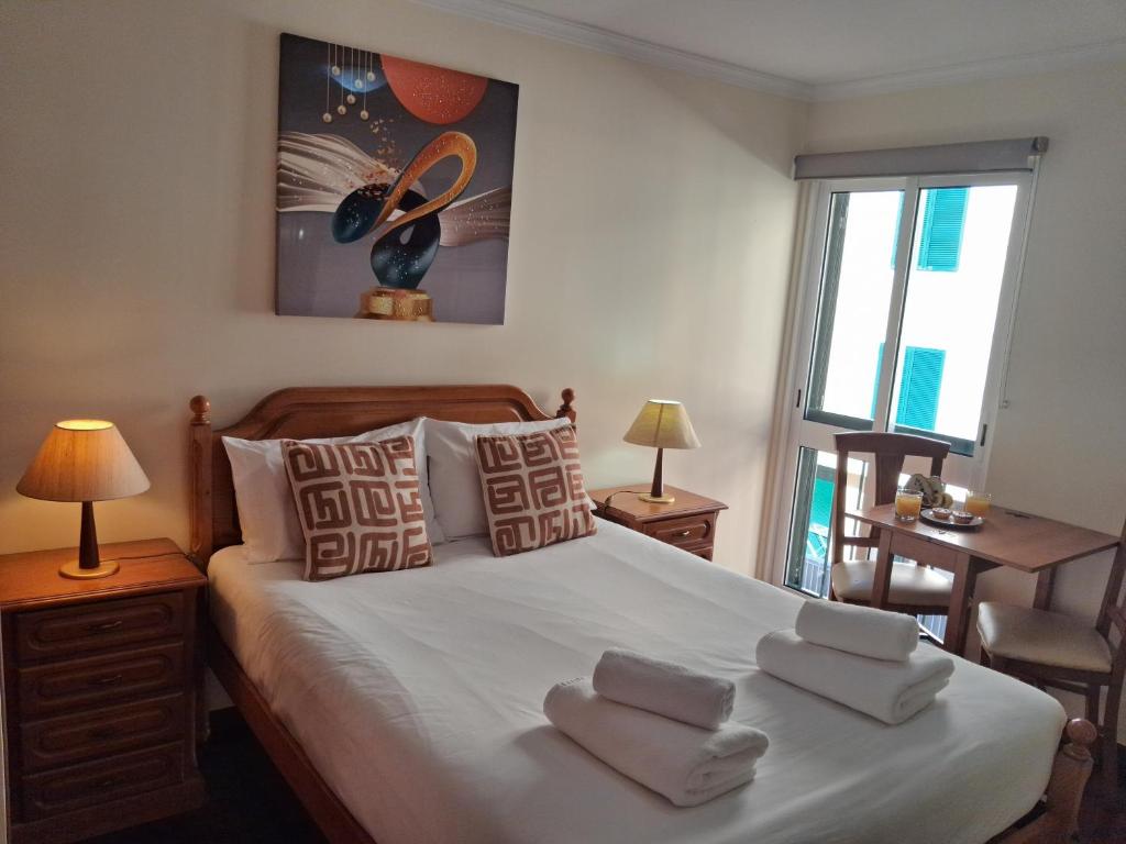 a bedroom with a large bed with towels on it at Ribeira Brava Studios - L in Ribeira Brava