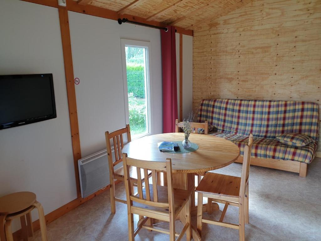 a living room with a table and chairs and a couch at Chalet Jonquille 1 in Plombières-les-Bains