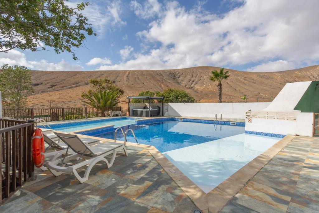 ein Swimmingpool mit einem Berg im Hintergrund in der Unterkunft Vivienda Vacacional Sara in Tetir