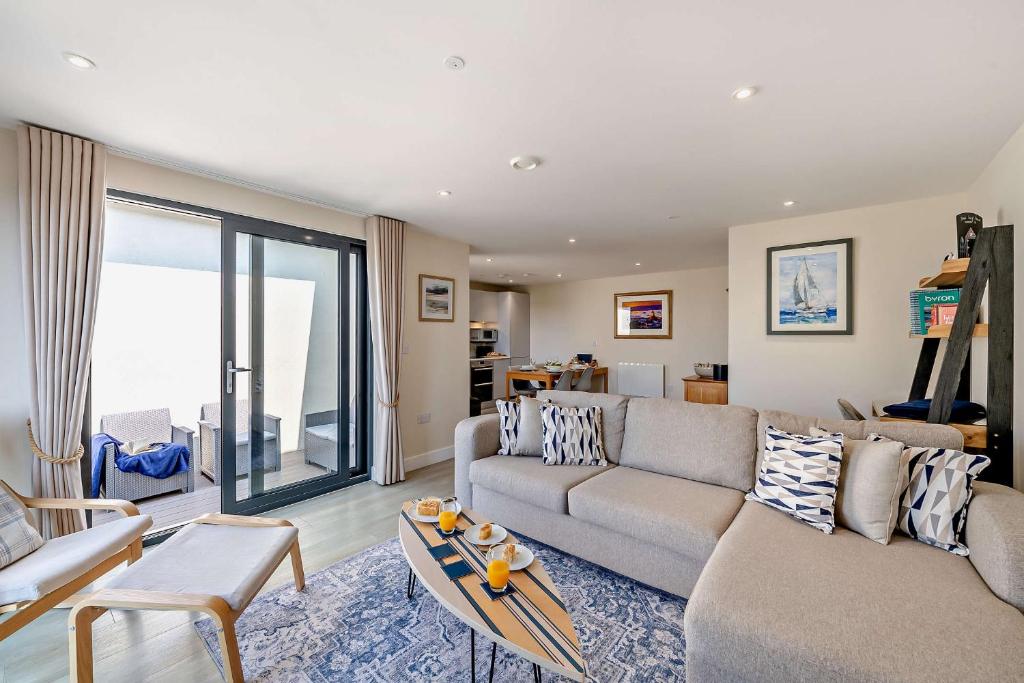 a living room with a couch and a table at 12 Middlecombe - Luxury Apartment at Byron Woolacombe, only 4 minute walk to Woolacombe Beach! in Woolacombe
