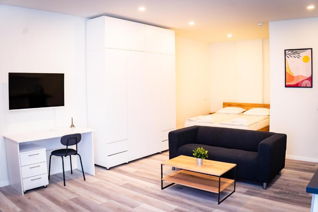 a living room with a couch and a desk and a bed at Urban76 Apartments in Târgu-Mureş