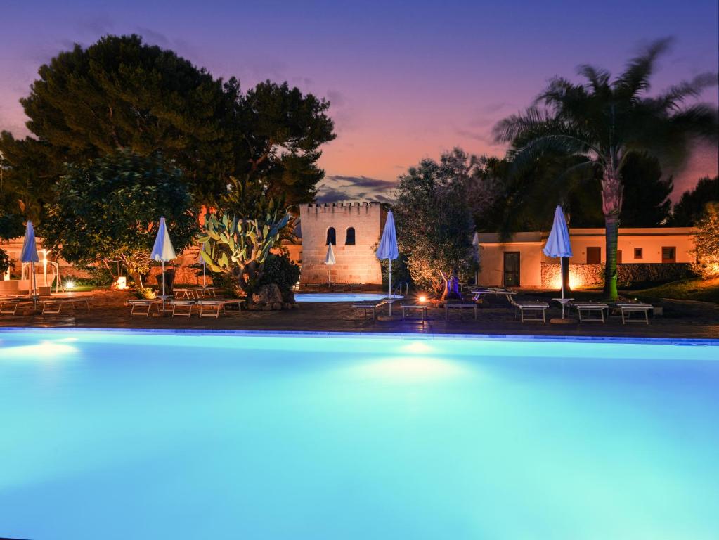 a view of a pool at a resort at night at Resort Villa Hermosa in Porto Cesareo