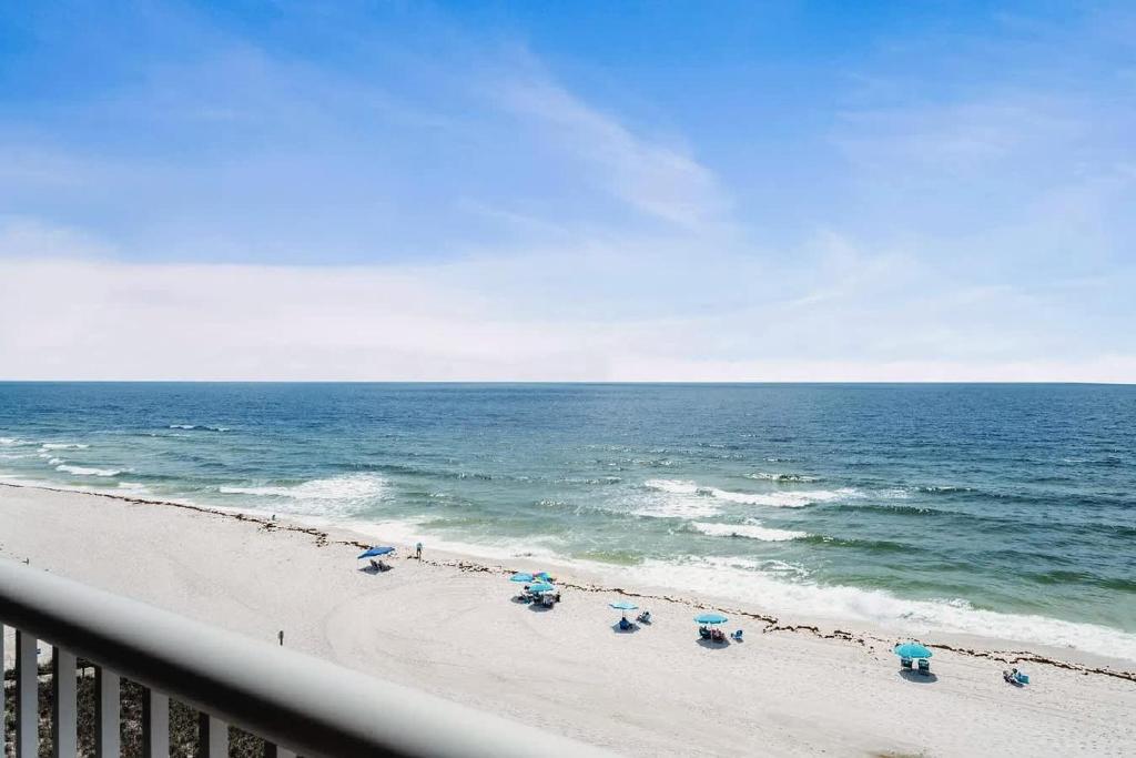 a beach with beach chairs and the ocean at 2 Bedroom Condo with Panoramic Views in Pensacola