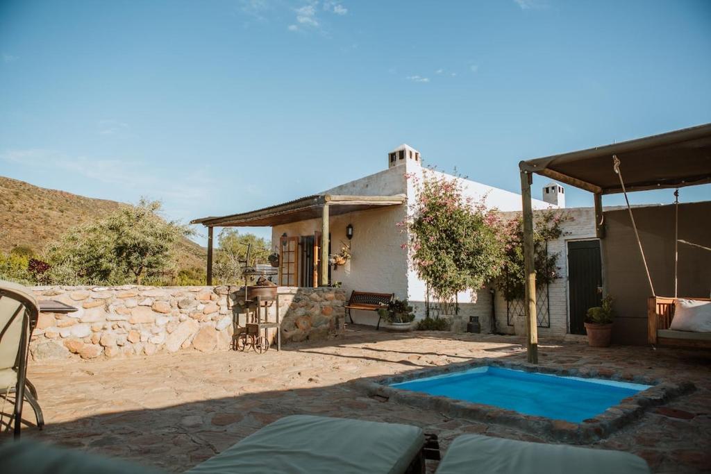 una casa con piscina en un patio en Wild Olive Cottage, en Graaff-Reinet