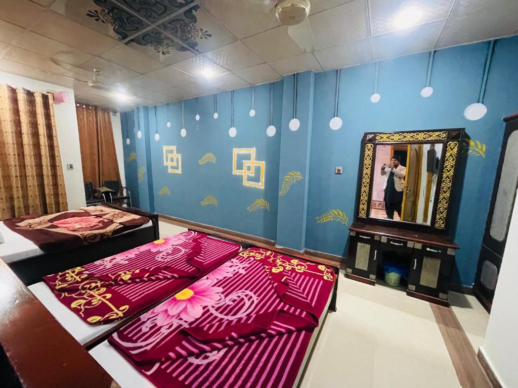 una stanza con due letti, uno specchio e una donna che scatta una foto di Green land hotel a Mingora