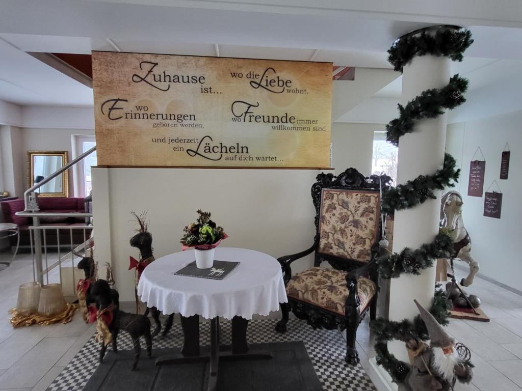 ein Zimmer mit einem Tisch und einem Schild an der Wand in der Unterkunft Landhaus Auhirsch in Böbrach