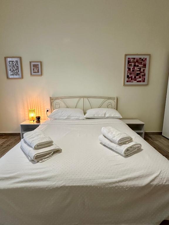 a bedroom with a white bed with towels on it at ESTIA Dionysos in Drama