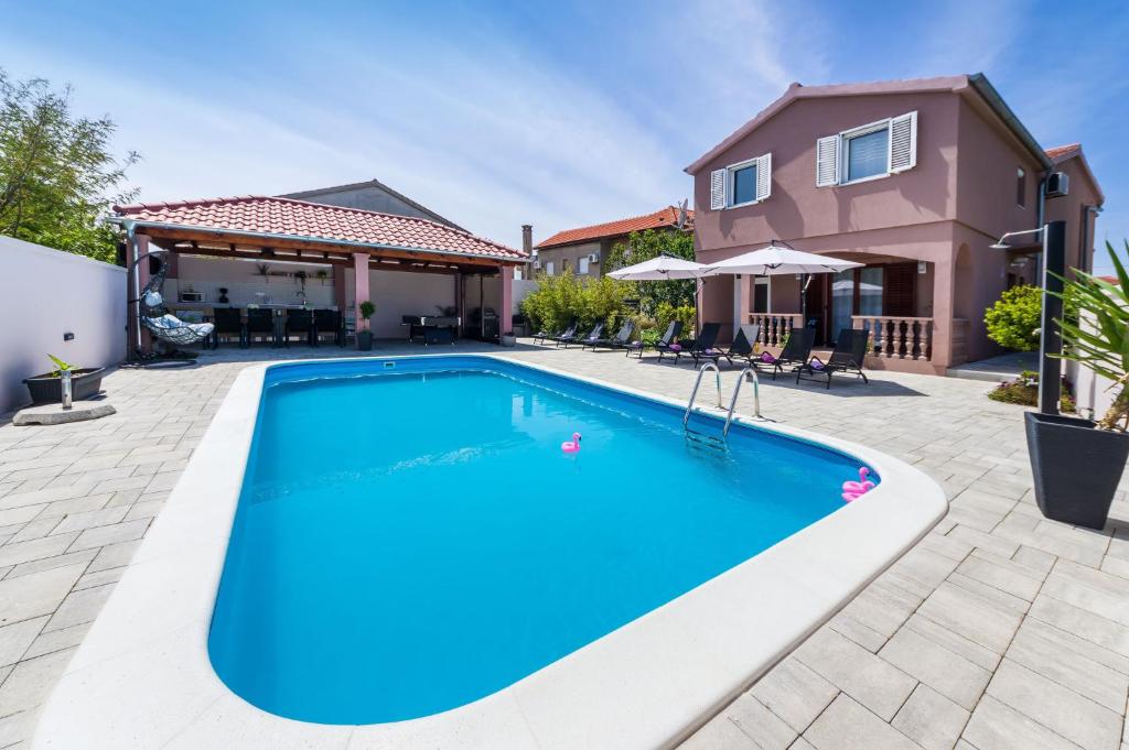 ein Swimmingpool im Hinterhof eines Hauses in der Unterkunft Villa Renata ZadarVillas in Zaton