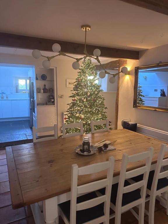 une table à manger avec un arbre de Noël en arrière-plan dans l'établissement Prior Hall Farm Cottage - 3 bedroom luxury cottage in center of Malham, à Malham