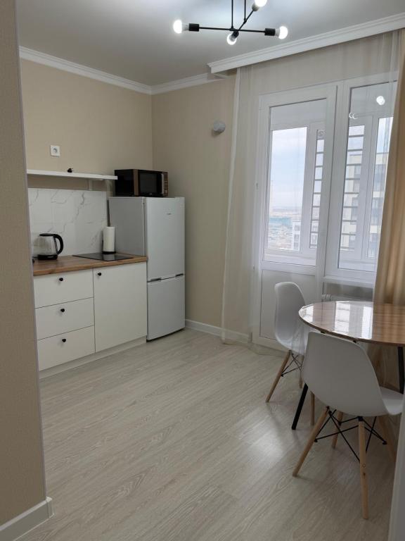 PrigorodnyyKvartira Astana的带桌子和椅子的厨房