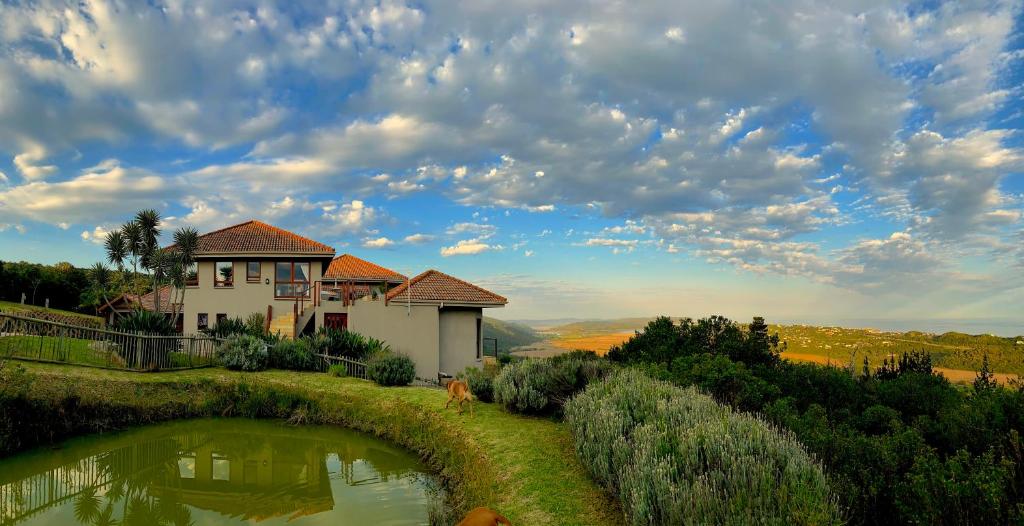 a house on top of a hill with a pond at Wilderland in Wilderness