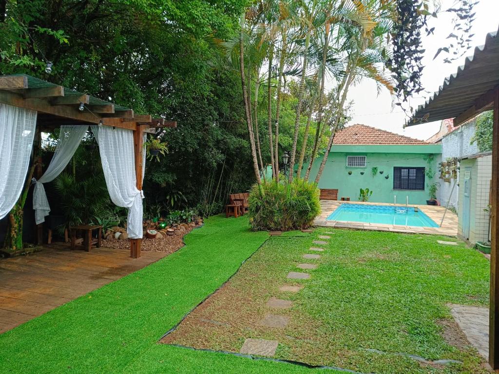 einen Hof mit einem Pool und einem Haus in der Unterkunft Open House Timboré in São Paulo