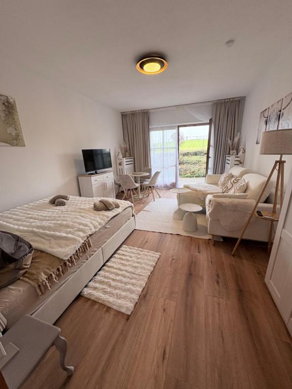 ein Schlafzimmer mit Bett und ein Wohnzimmer in der Unterkunft Chiemsee-Perle, stylisches Luxus-Appartement in Rimsting