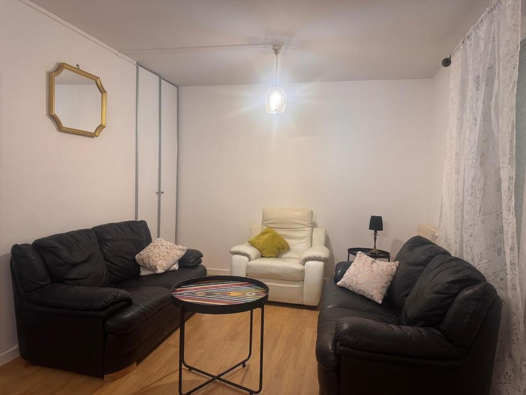 a living room with two couches and a table at La Maison du Routard in Évreux