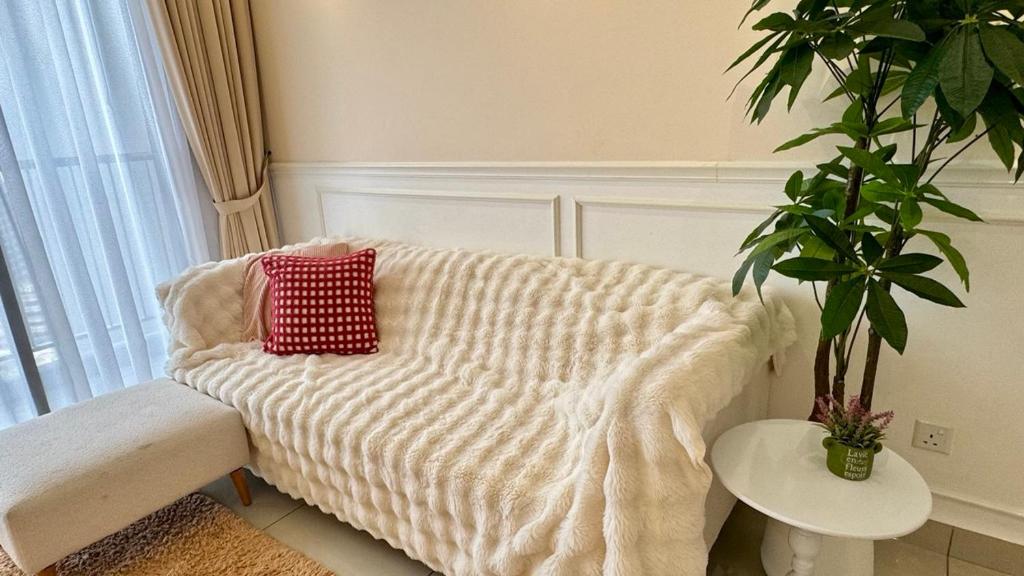 biała kanapa z czerwoną poduszką w salonie w obiekcie Twin Tower Residence Brand New Minimalist Suite 7pax 3 Min Walk from CIQ w mieście Johor Bahru