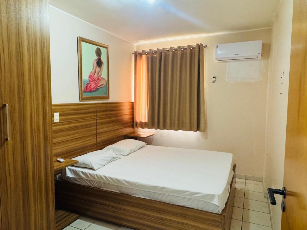 um pequeno quarto com uma cama com janela em Thermas Paradise resorts em Rio Quente