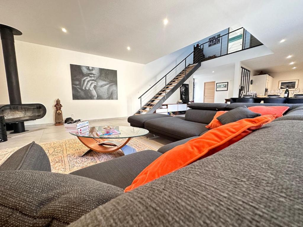 ein Wohnzimmer mit Sofa und Tisch in der Unterkunft Calme et détente avec jacuzzi, jardin et terrasse in Trigny