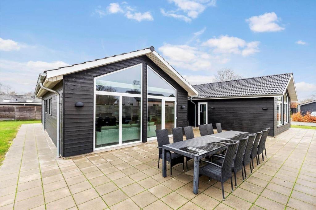 菲耶勒鲁普8876-Glesborg-Strandvejen-43的带桌椅的露台和一栋房子