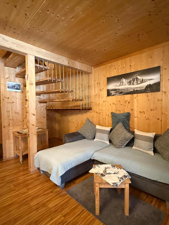 two beds in a room with wooden walls at Ferienhaus Messner in Hohentauern