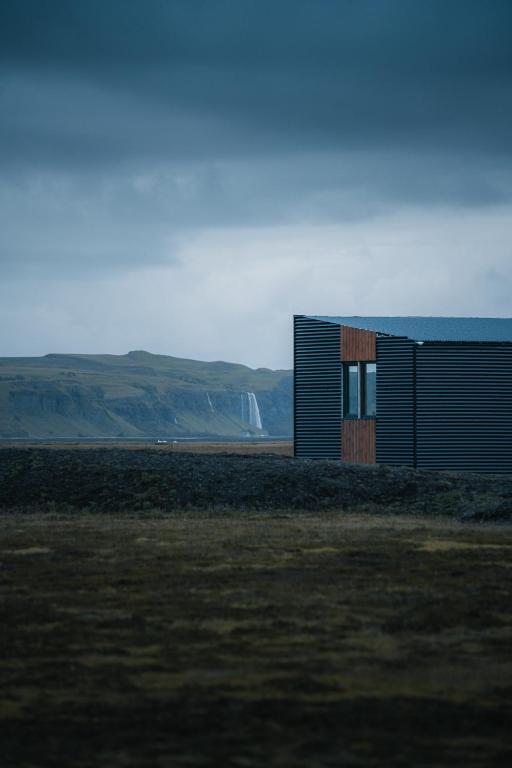 a small building in the middle of a field at Seljalandsfoss cottage in Hvolsvöllur
