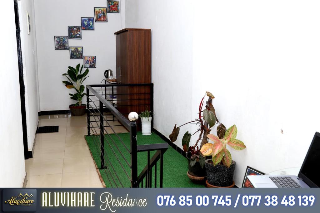 een kamer met een stoel, wat planten en een laptop bij Aluvihare Residence in Matale