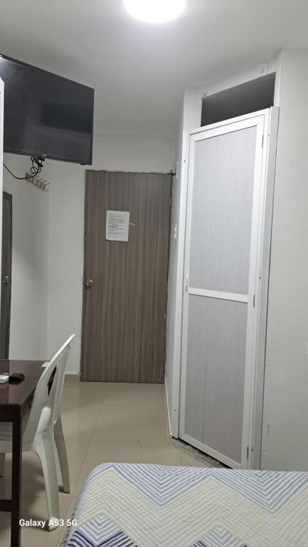 蒙特里亚Arriendo comfortables habitaciones amobladas por meses y días的一扇门通往一个房间，房间里有一张桌子，还有一张桌子，还有一张桌子。