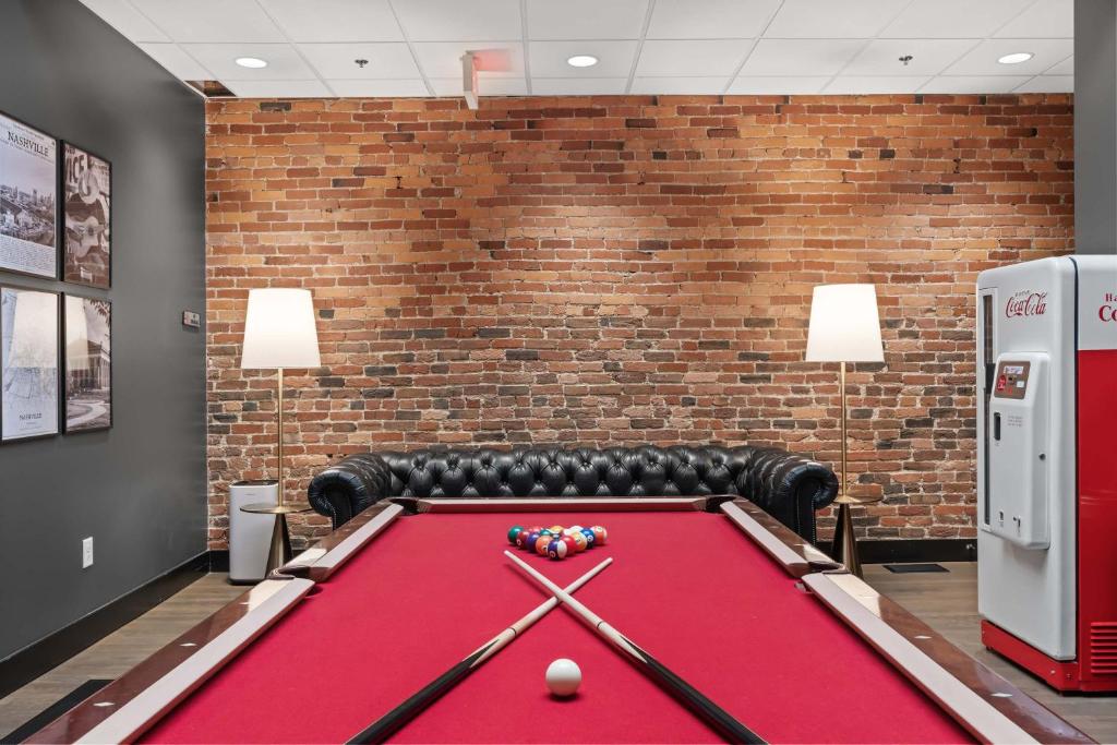 a pool table in a room with a brick wall at French's Luxury Condo - Steps from Broadway in Nashville