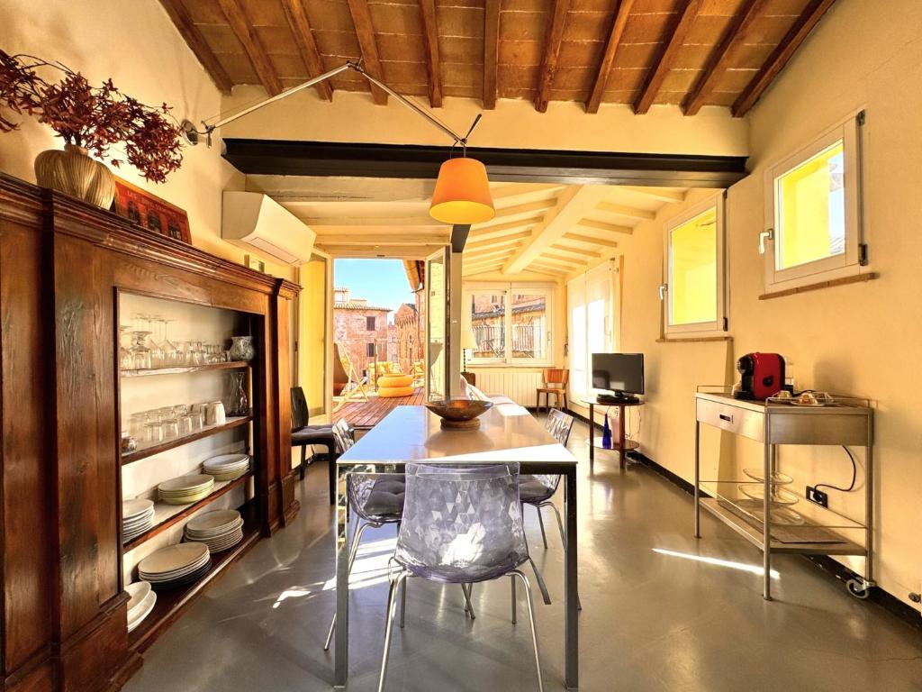a dining room with a table and chairs at LA COSTARELLA - Central with Cozy Terrace in Siena