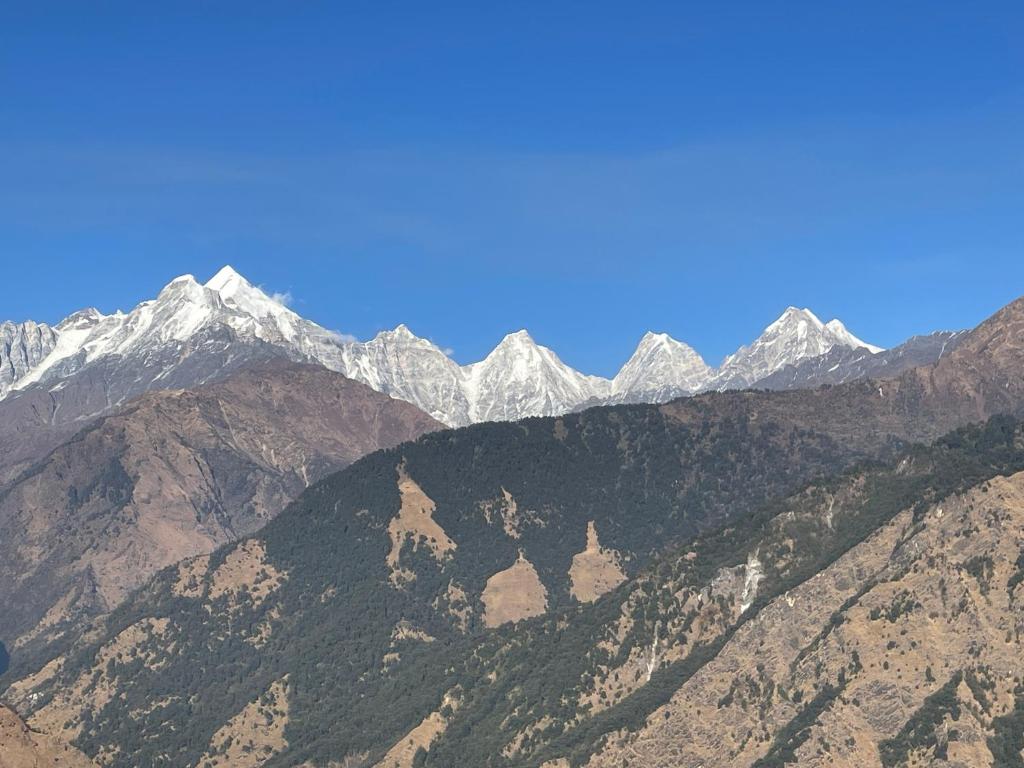 a view of a mountain range with snow covered mountains at Munsiyari Eco homestay in Munsyari