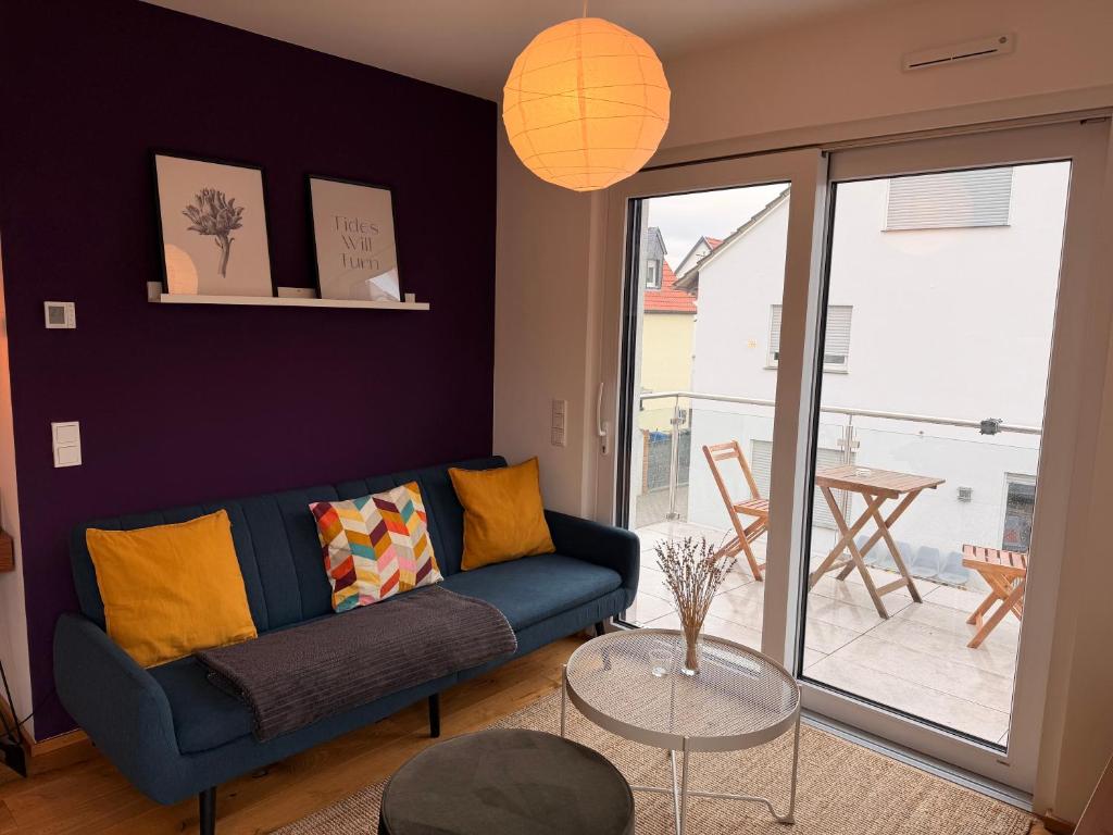 a living room with a blue couch and a glass table at Gemütliches Wohnen in Worms