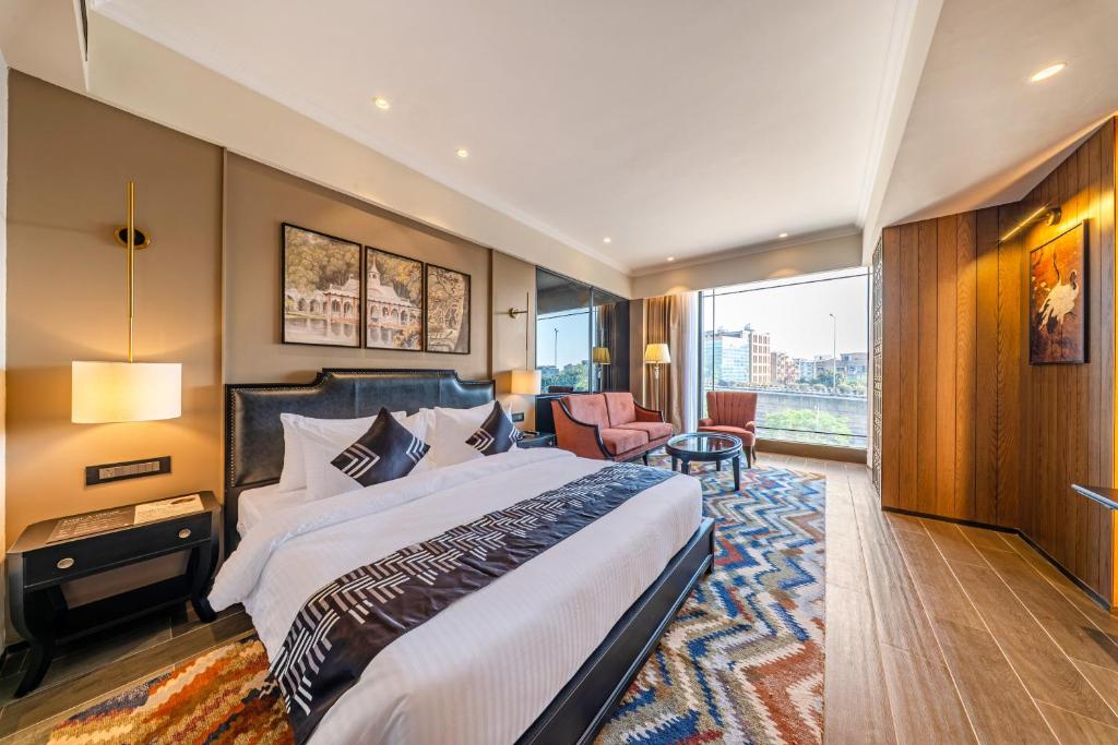 ein Hotelzimmer mit einem großen Bett und einem großen Fenster in der Unterkunft Medalio Signature Chandigarh Zirakpur in Zirakpur