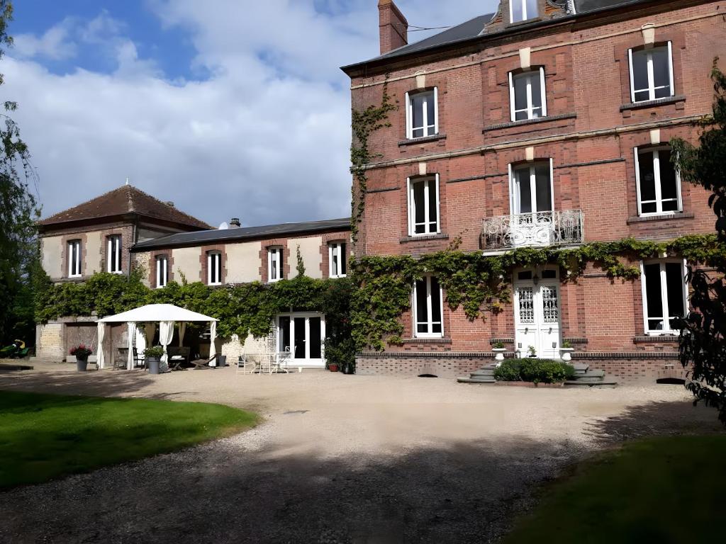 a large brick building with a large courtyard at Chambres à la campagne La Tuilerie in Prêtreville
