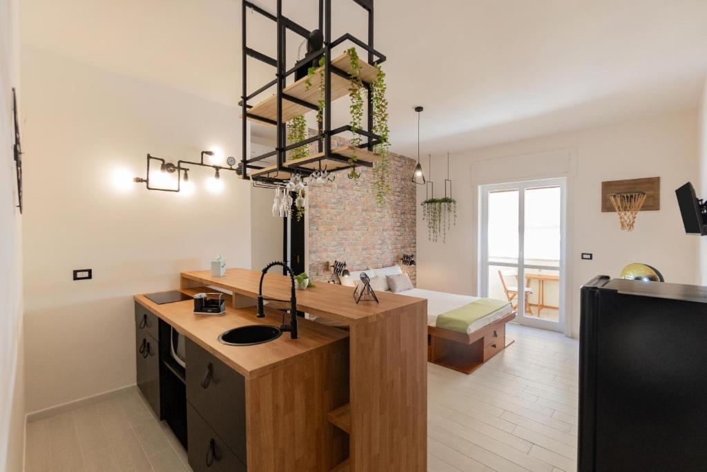 una cucina con lavandino e lampadario pendente di Dimore di Matilde - Mare Fuori a Gallipoli