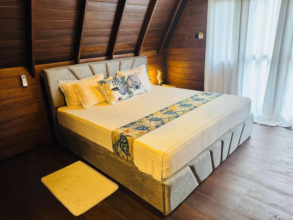 希克杜沃Soluna Cove Cabanas Hikkaduwa的一间木墙房间里的一张大床