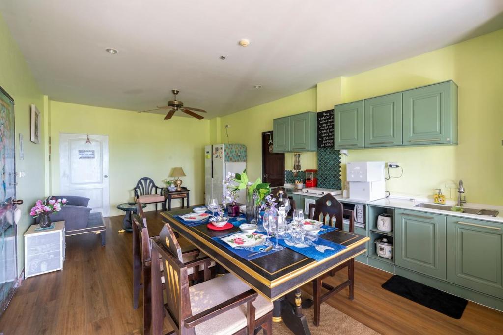 AoNang BeachFront 2BR Night market في شاطيء آونانغ: مطبخ وغرفة طعام مع طاولة وكراسي